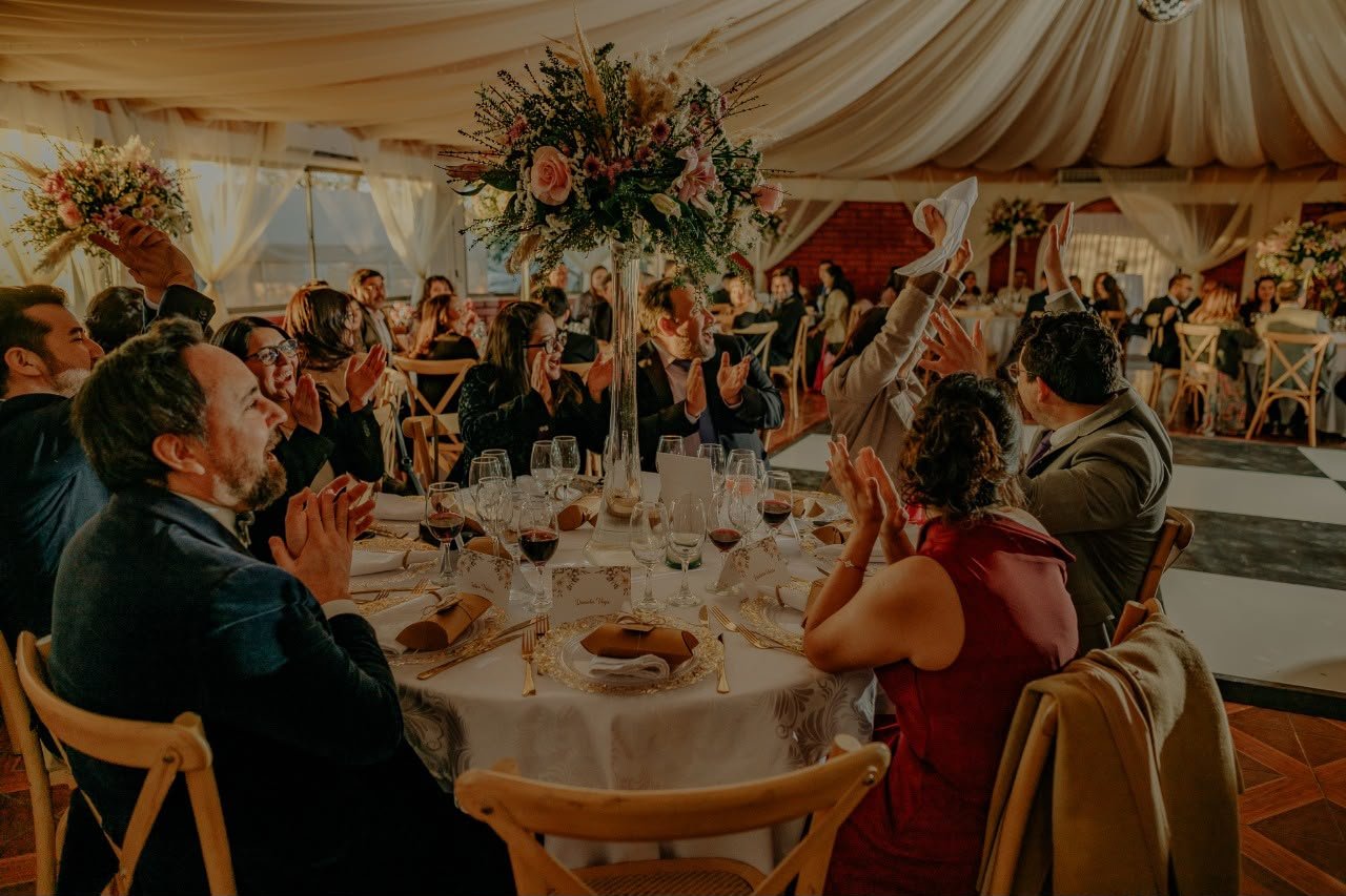 Invitados celebrando en el salón cerrado